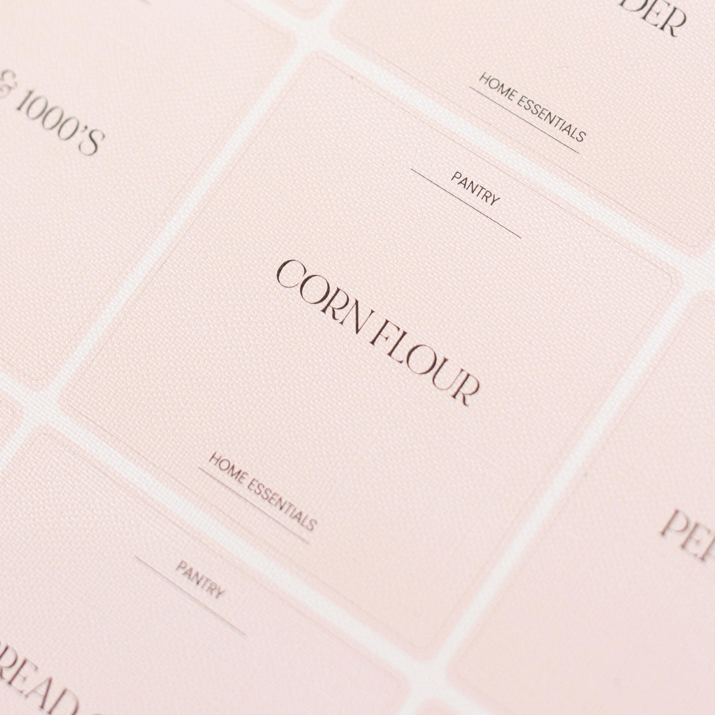 Close-up view of pink, nude Luxe Minimalist sticker Labels with white text on clear labels, showing 'Cereal', 'Oats', and 'Rice