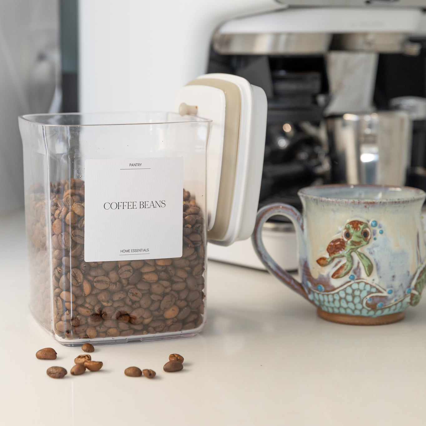 Container of coffee beans with a coffee machine and mug in the background