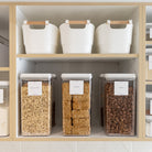 Storage shelves with labeled containers in a kitchen setting