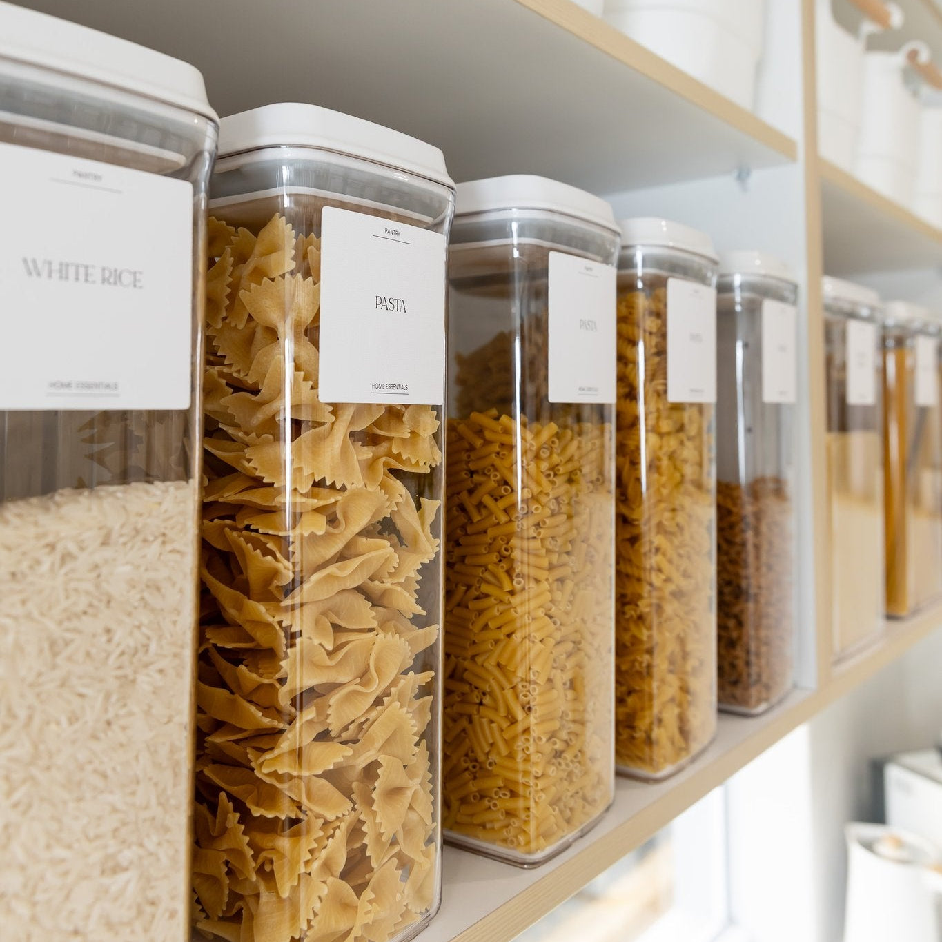 Pantry shelves with clear storage conatiners labeled with food items