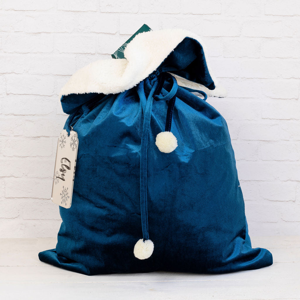 Reusable velvet Santa sack with personalised tag, a sustainable alternative to wrapping paper.