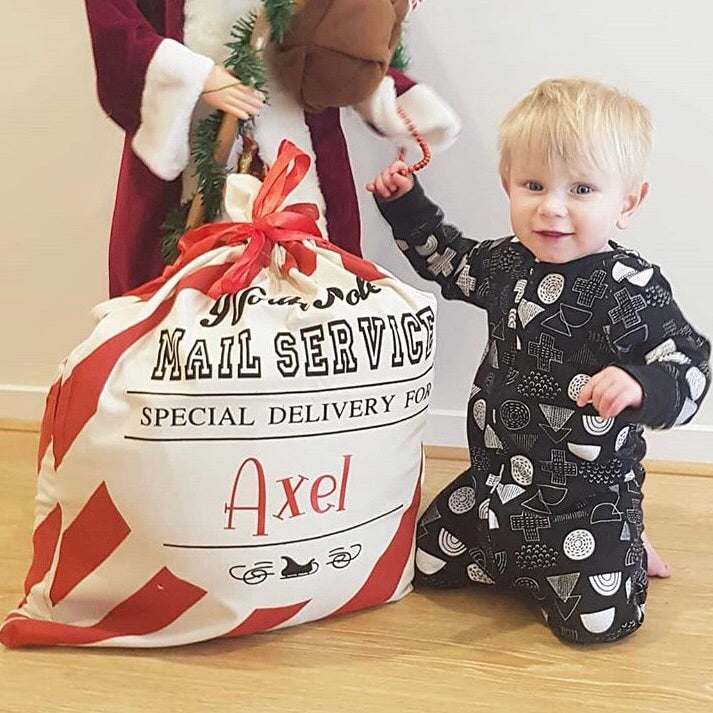 Display of personalised candy stripe Santa sacks, ideal for Christmas traditions.