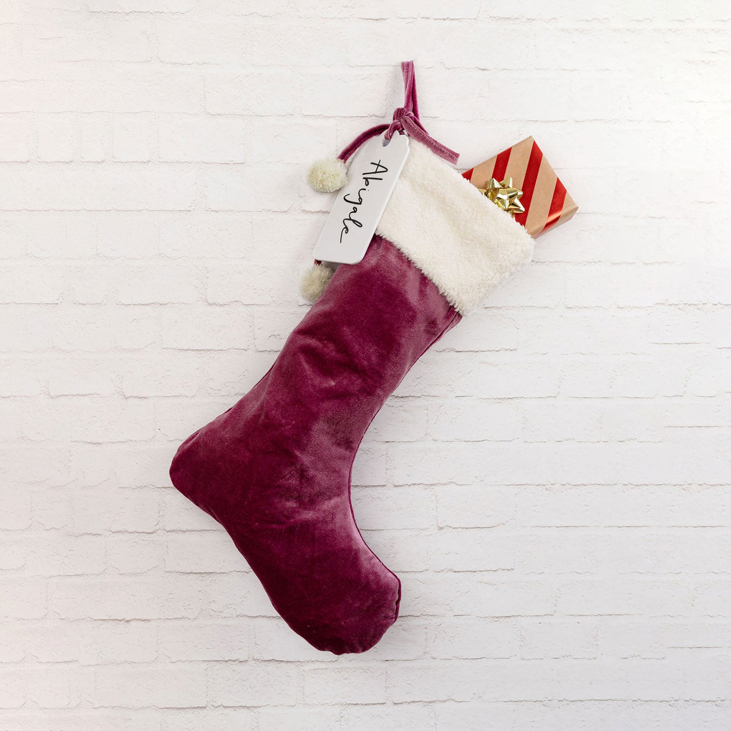 Velvet Santa stocking filled with presents, ready for Christmas morning.