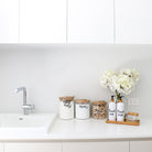 Versatile bamboo and glass jars used for storage in a stylish kitchen.