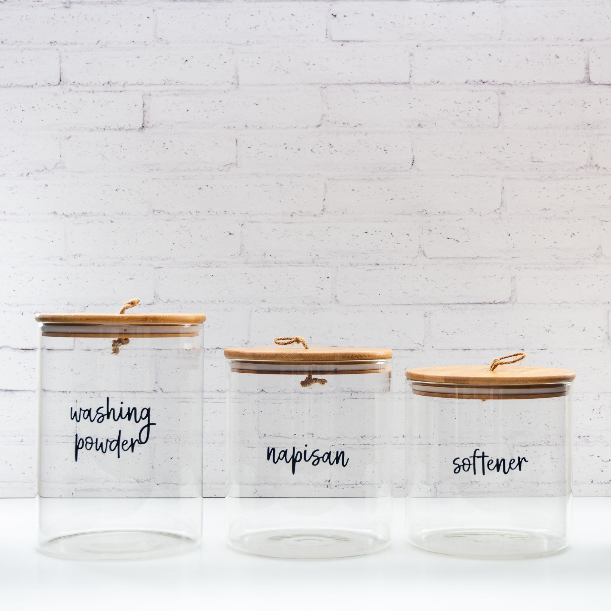 Custom labelled bamboo and glass storage jars for organised living.