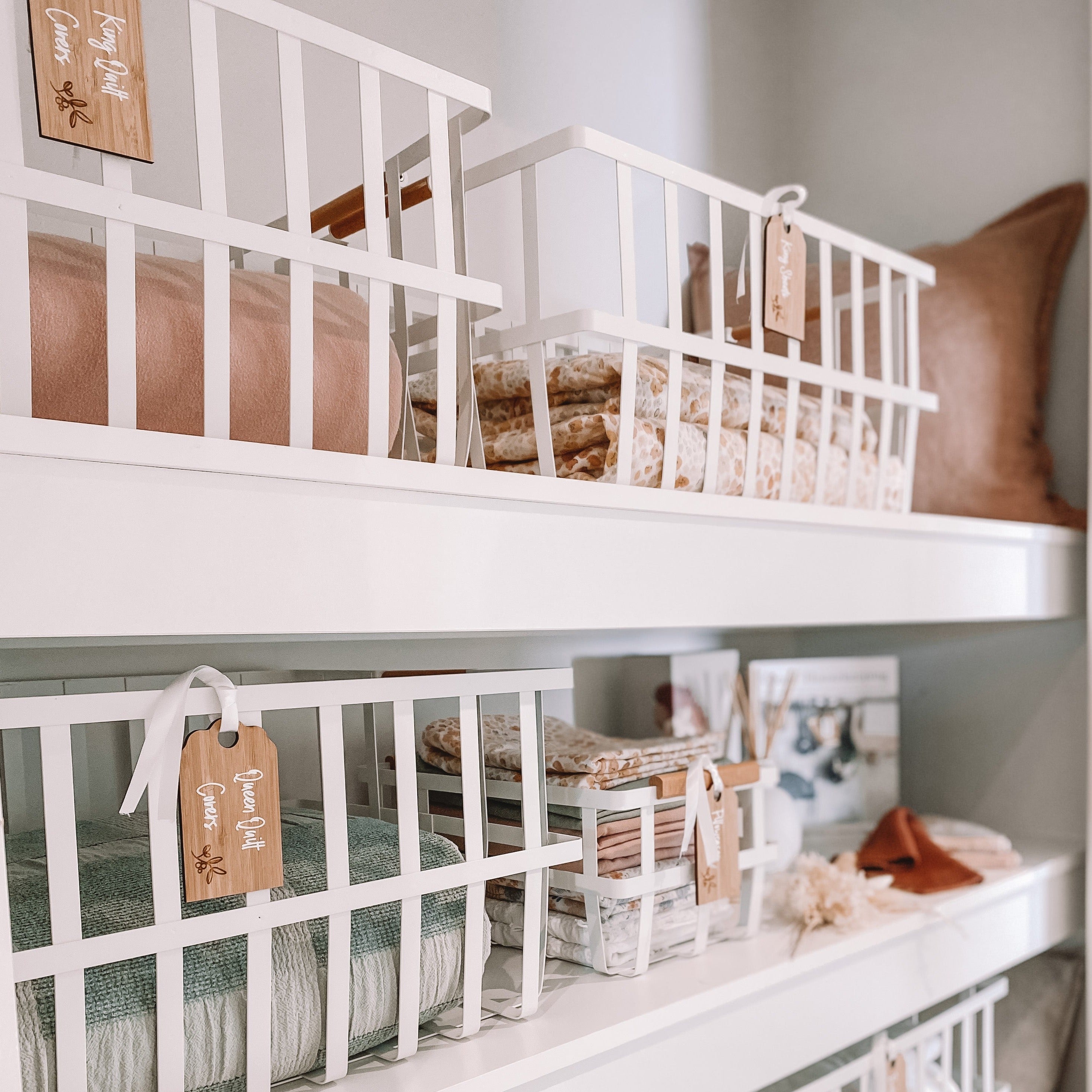 Medium white storage baskets for smaller linen items like hand towels and face cloths.