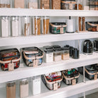 Stackable black push top containers for space-efficient pantry storage.